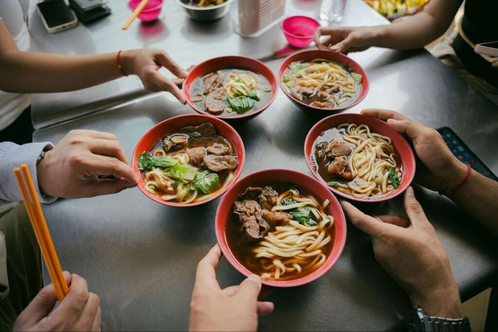 Group sharing a communal meal during a culinary tour experience